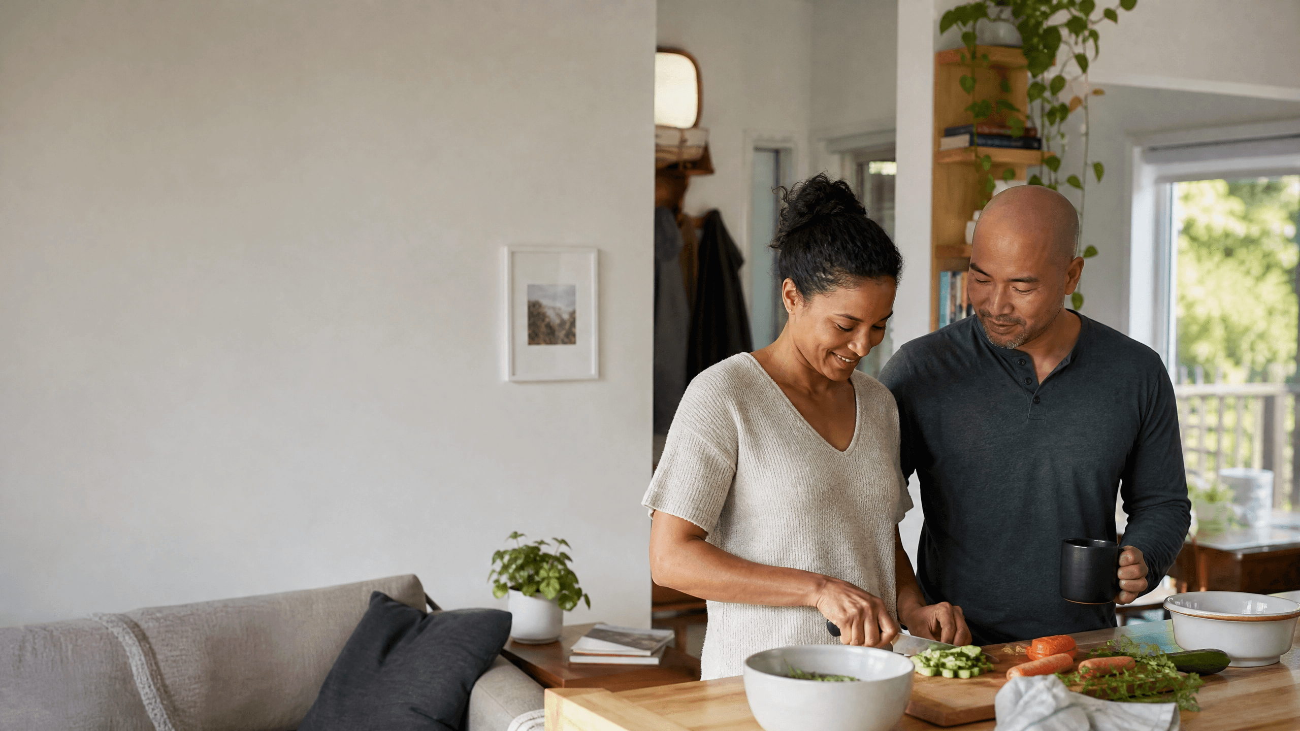 Un couple prépare le repas dans la cuisine ouverte de sa maison.